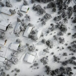An aerial shot of a suburb of houses in winter covered in snow.