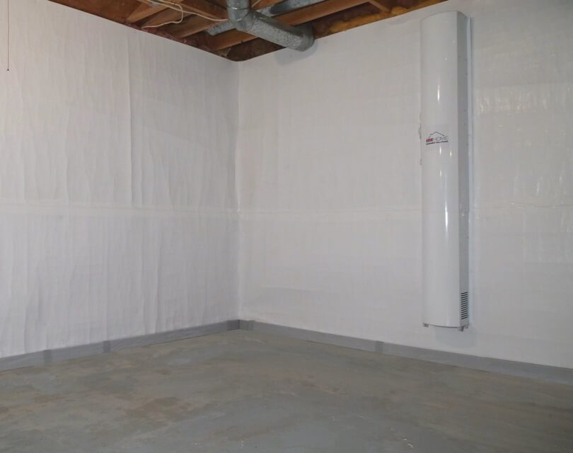 Unfinished basement with white barrier along the walls and Erie Home appliance installed