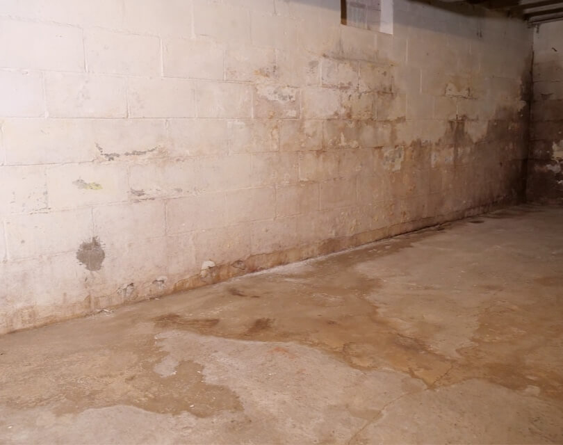 Water seepage and residue on interior foundation wall and basement floor