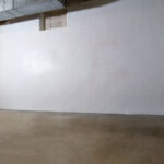 A completed Erie Home waterproofed basement with the clean white encapsulated walls.