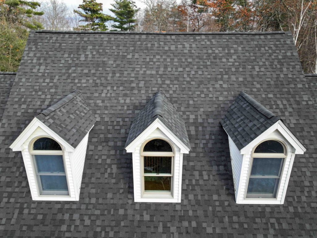 A medium shot of an asphalt roof with windows facing out.