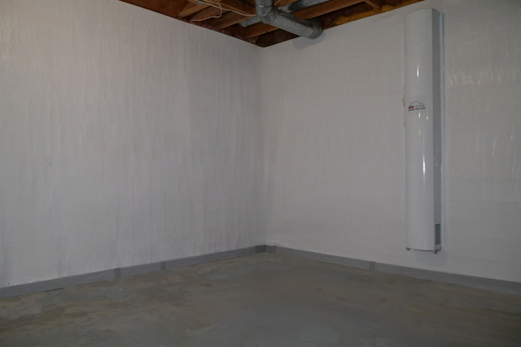 A real waterproofed basement completed by the Erie Home team. We see the white encapsulation on the walls. Attached to the wall is the air filter system.