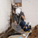 An Erie Home employee installing a sump pump for a customer.