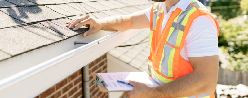 man inspecting a roof