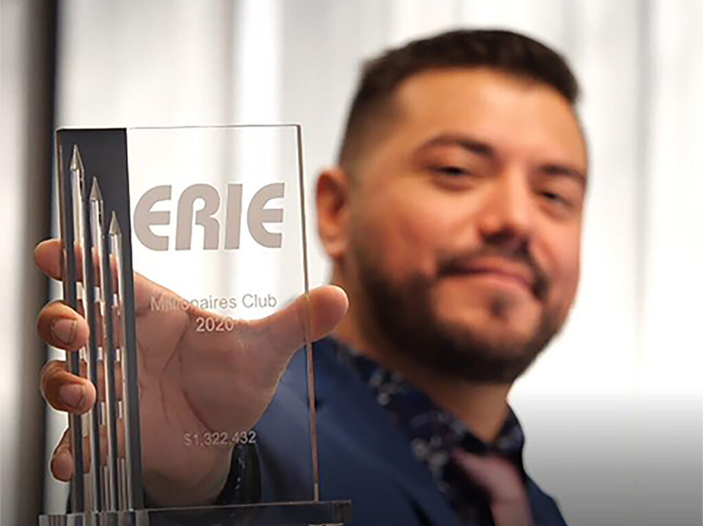 A sales rep holding a Millionaires Sales Club Trophy.
